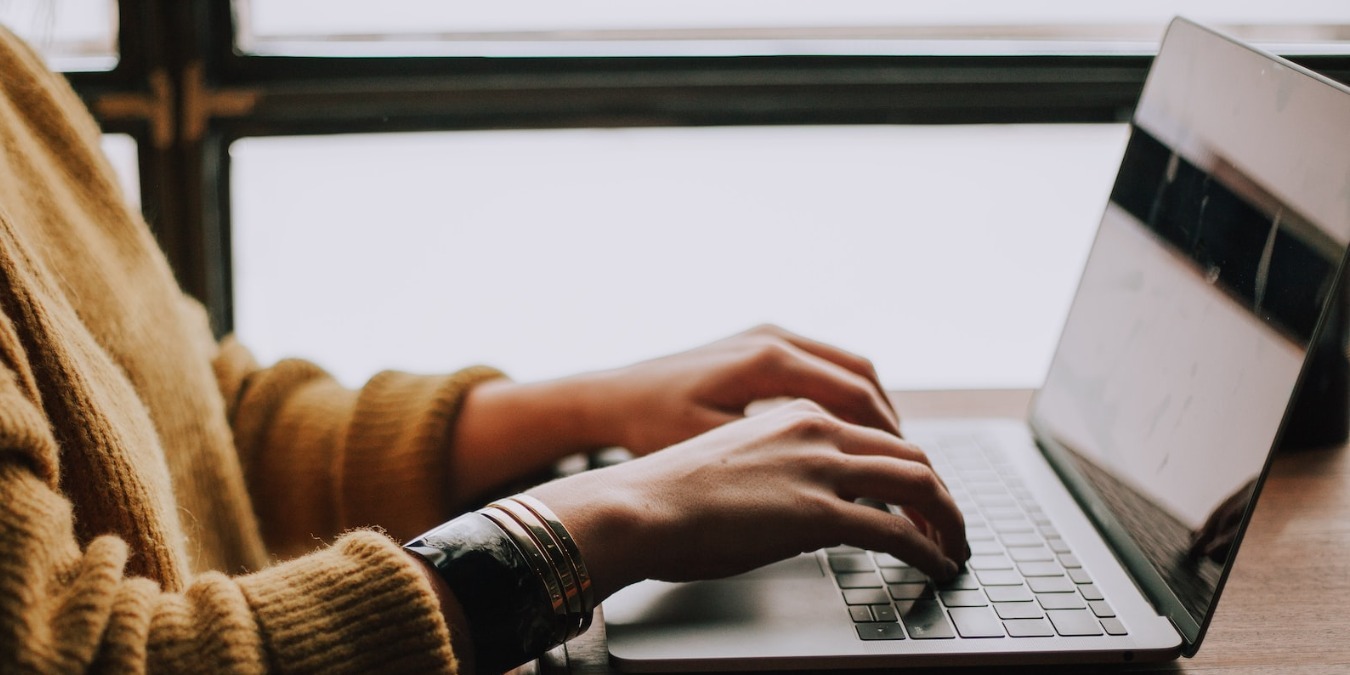 Person sitting in front of and working on a laptop