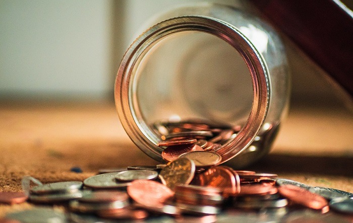 A jar on its side with coins coming out of it