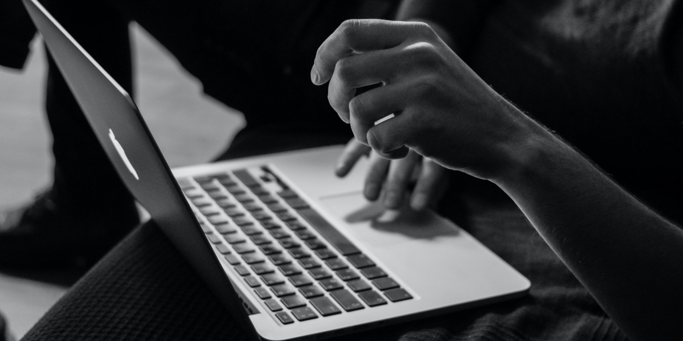 A person typing on a laptop keyboard.