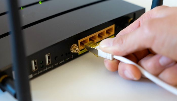 Inserting Ethernet cable in router.