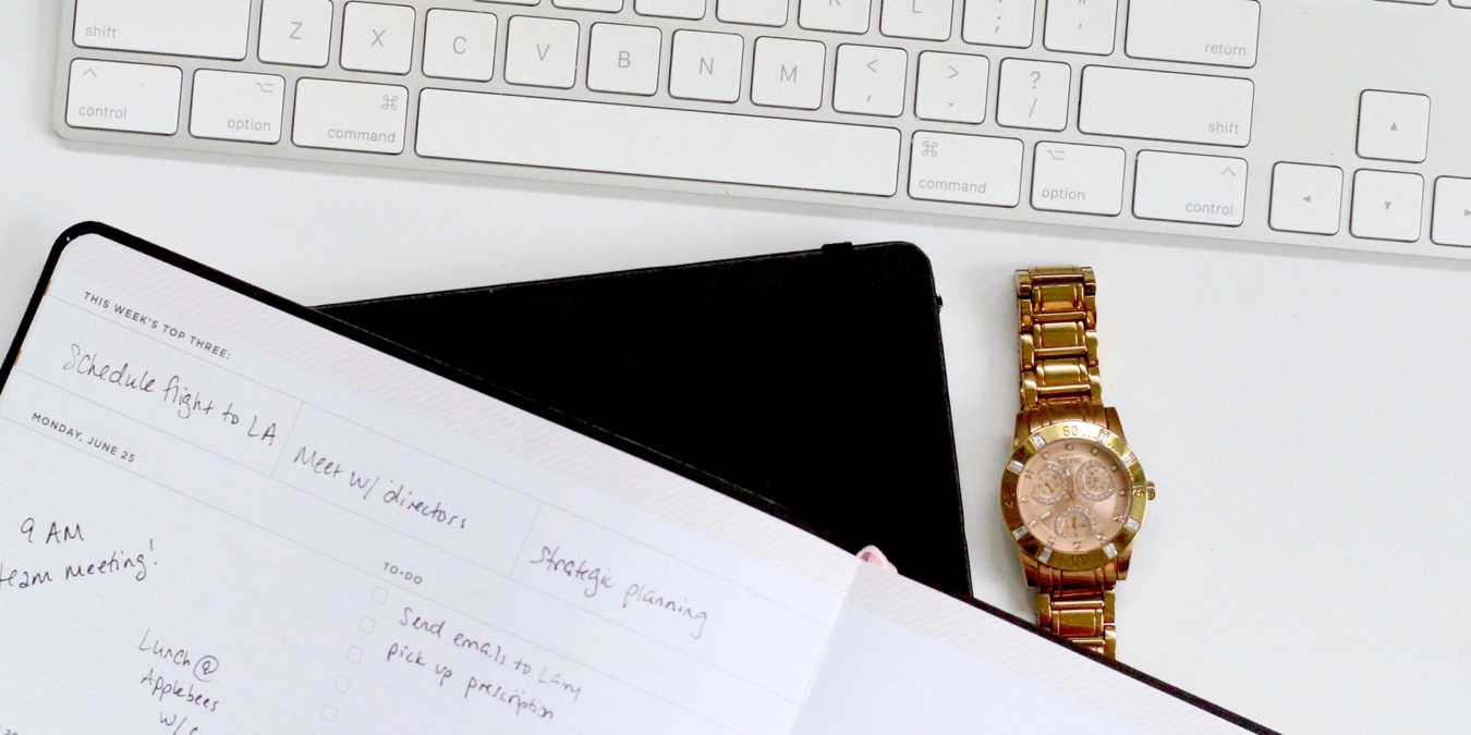 Mac keyboard with a watch and planner
