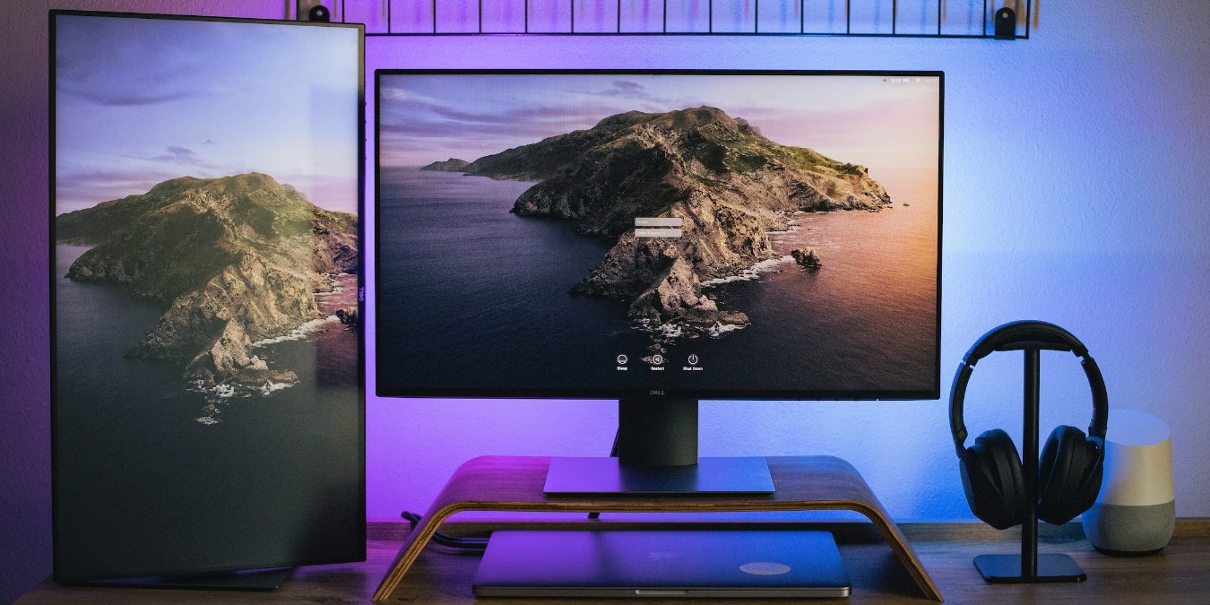 horizontal and vertical monitors on a wooden desk