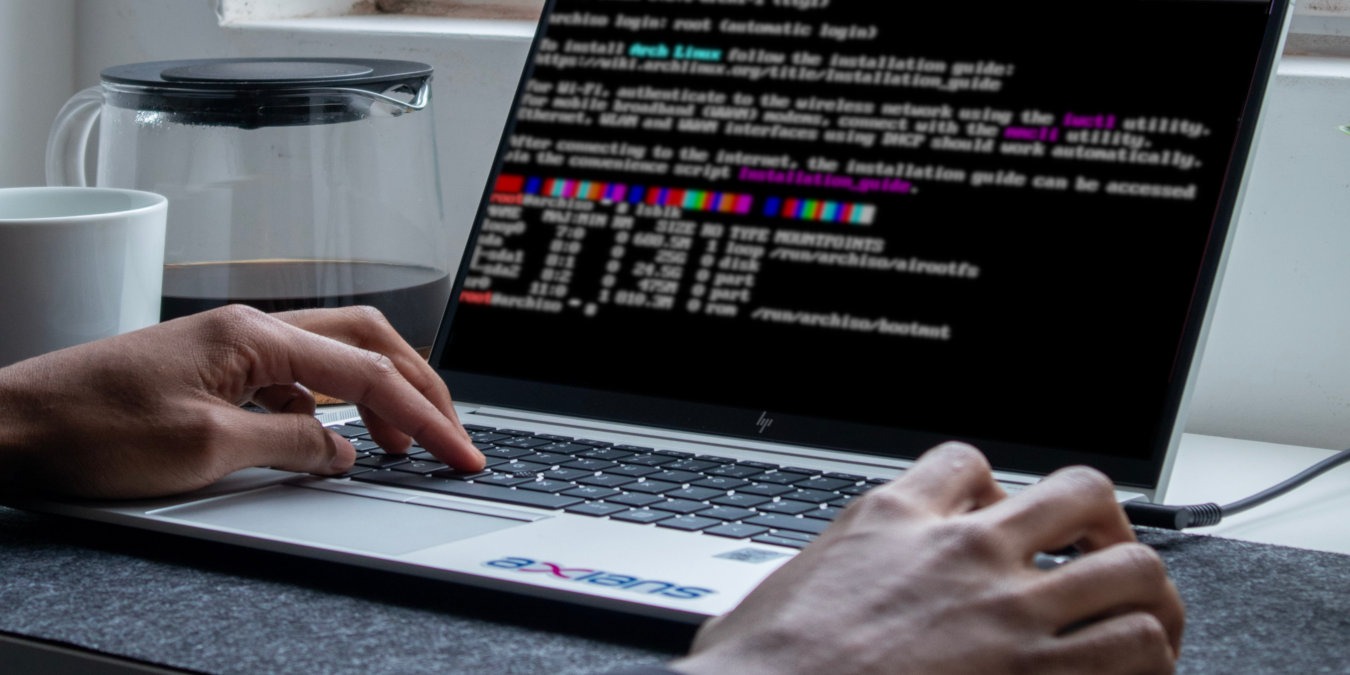 A photograph of a person using a laptop in a table.