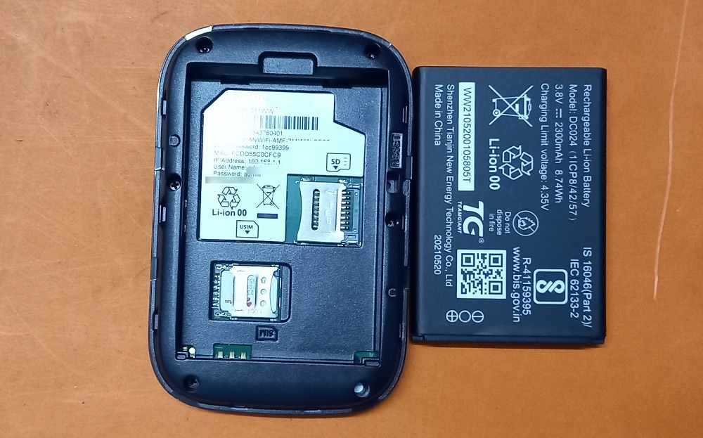 SIM card reinserted into its available slot in Mi-Fi device with battery visible.