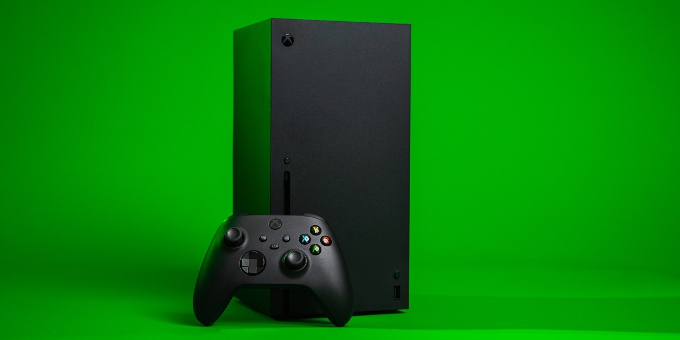 Xbox Series X console with a controller against a green background