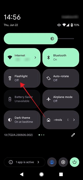 Tapping on "Flashlight" tile in Android's Quick Settings.