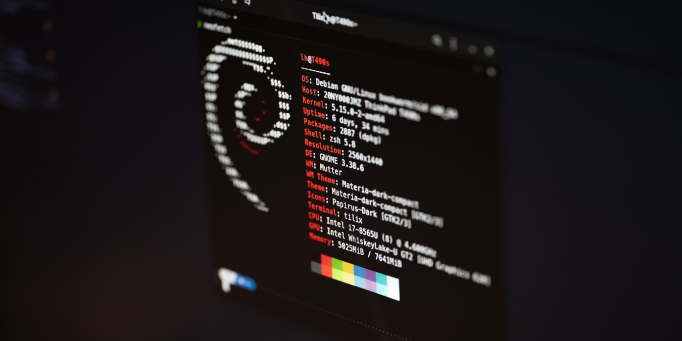 A photograph of a computer monitor showing the output of neofetch.