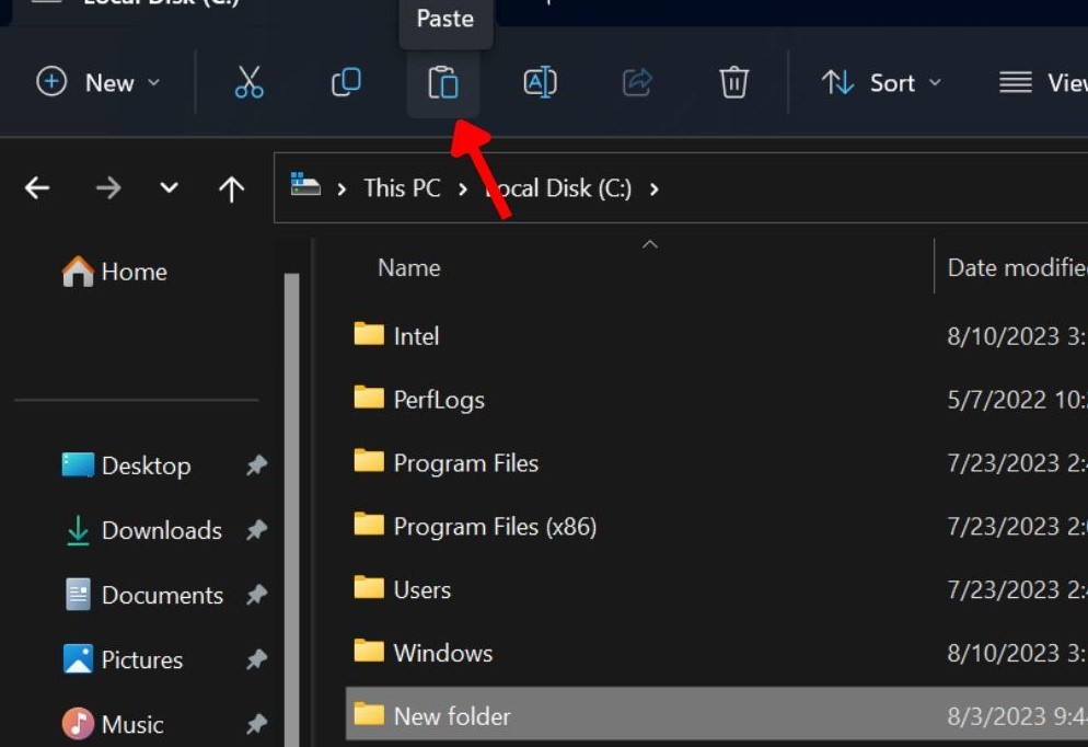 Clicking the paste icon from the top bar in File Explorer.