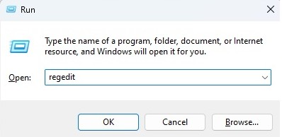 Typing "regedit" in Run dialog to launch Registry Editor.