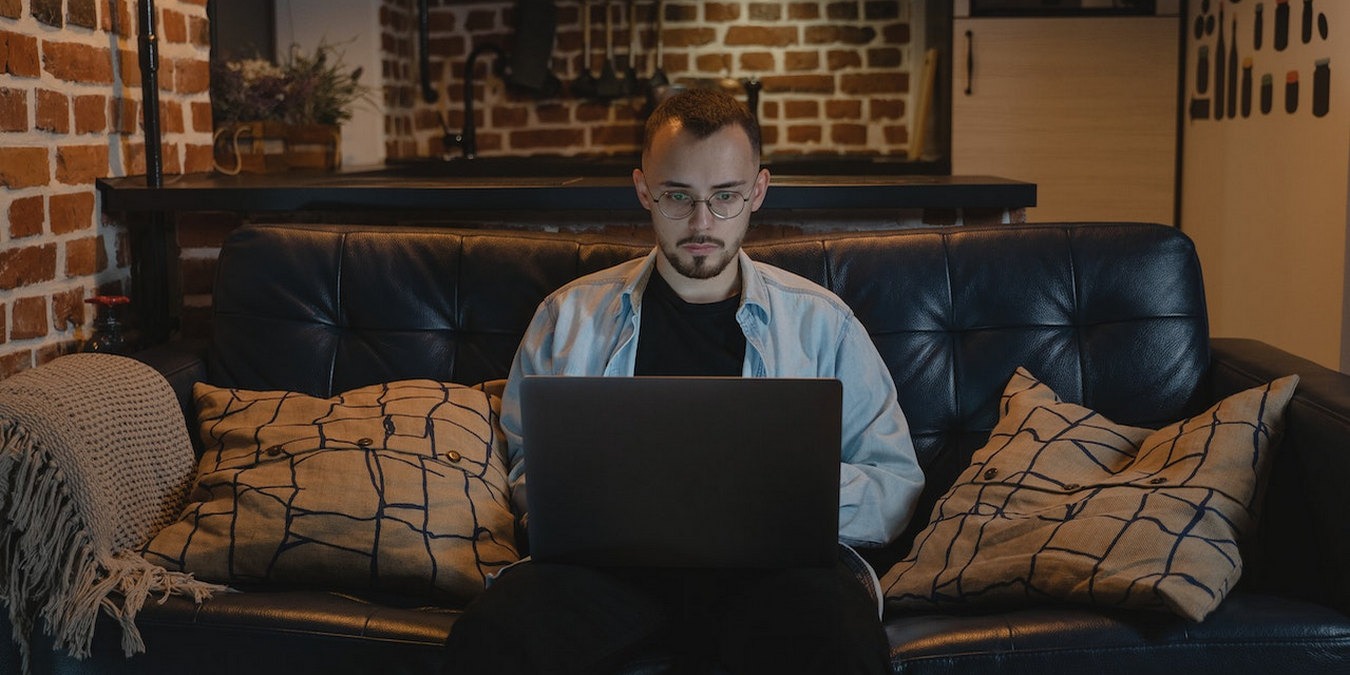 Person Working On Laptop On A Couch