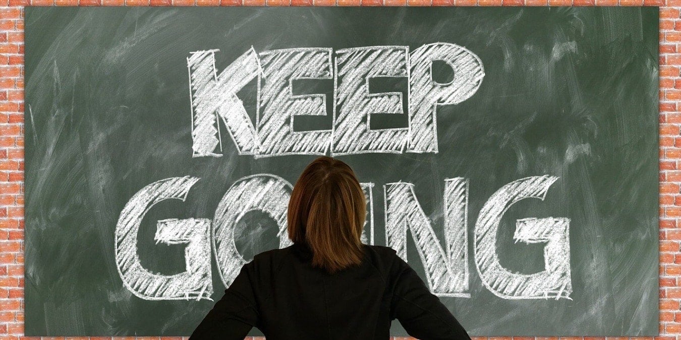 Keep Going on a chalkboard with a woman