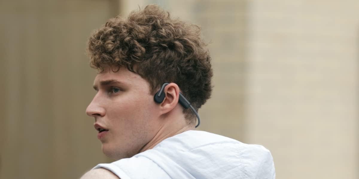 Young Man Listening to Music With Bone Conduction Headphones by Shokz
