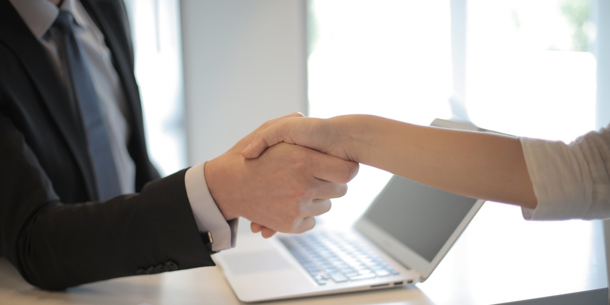 Two people shaking hands over a deal. 
