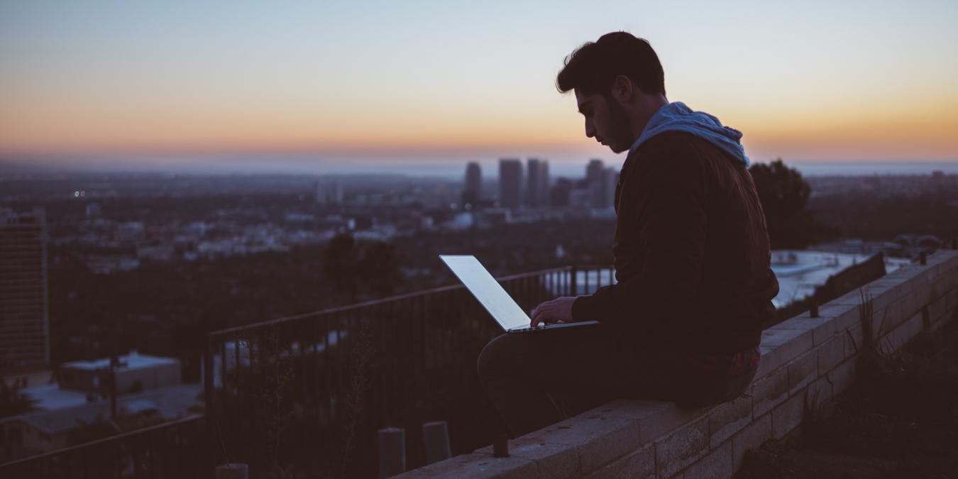Person Typing On Laptop Over A Building Feature Image For Popular Reddit Acronyms