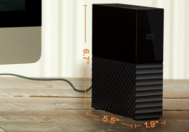 WD My Book 12TB Black external hard drive on a brown desk next to a computer