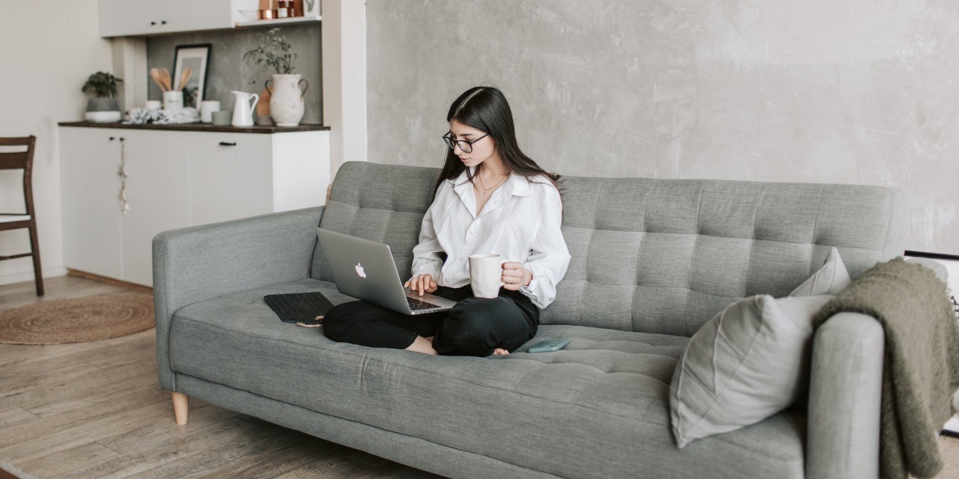 Woman sitting on sofa working on lapop