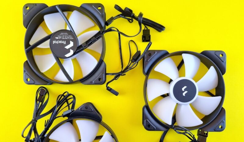 A couple of PC fans on a yellow surface