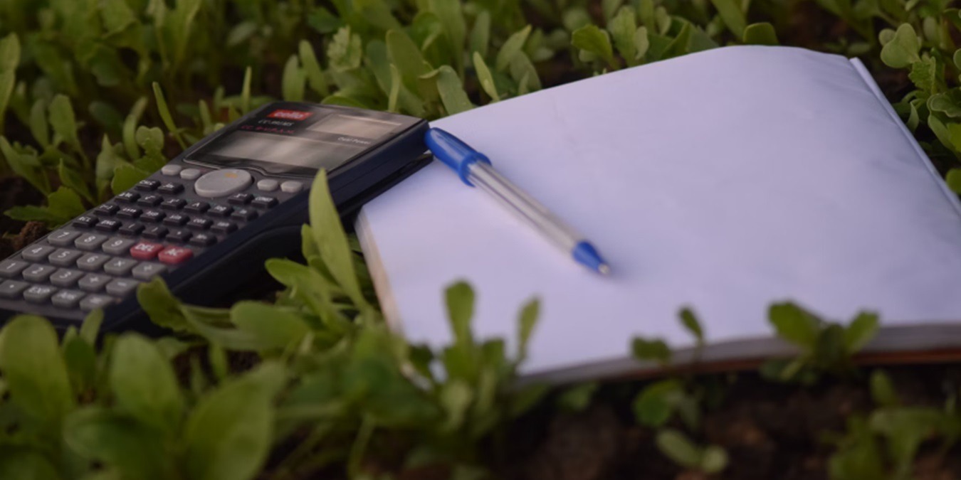 Calculator and pen with a pad of paper.