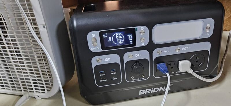 Power station with fan, refrigerator, and freezer plugged in.