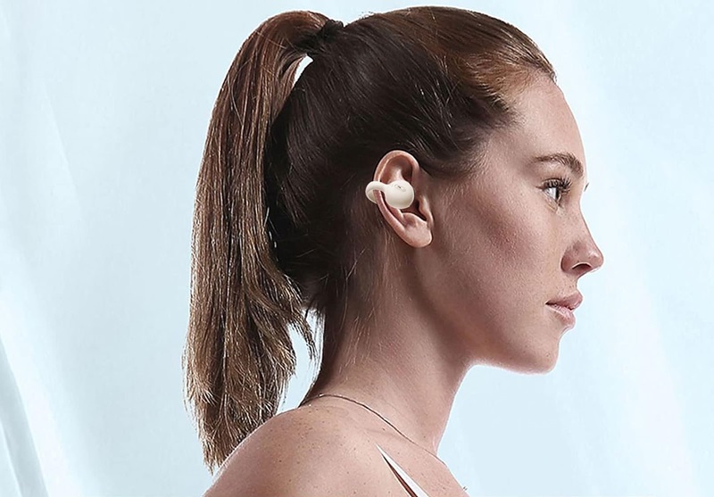 Woman wearing clip-on ear headphones.