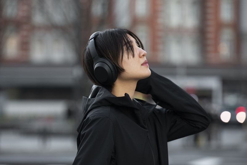 Woman wearing closed-back headphones. 