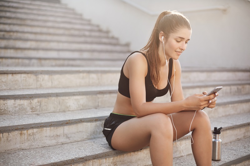 Woman listening to music through earbuds.