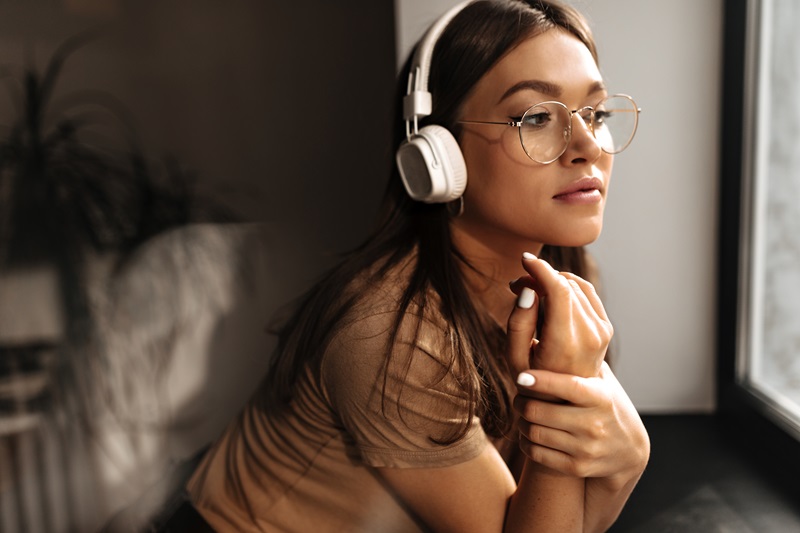 Woman wearing open-back headphones. 