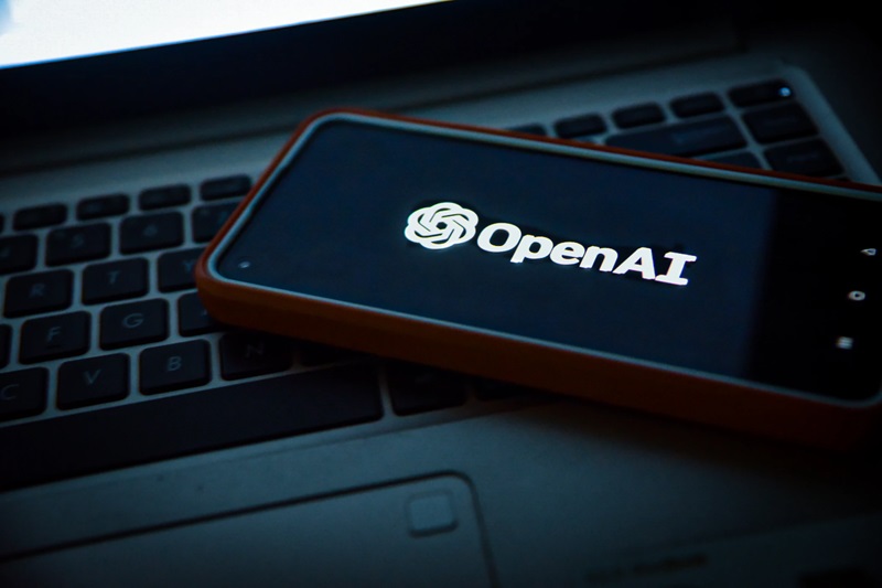A phone displaying the name OpenAI, the software behind ChatGPT.
