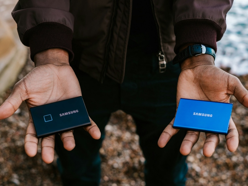 Person holding external drives in both hands