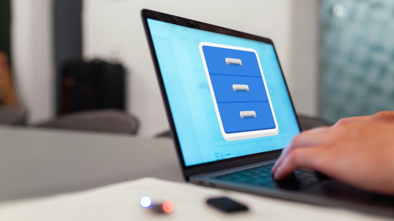 A photograph of a person typing on a laptop in a table.
