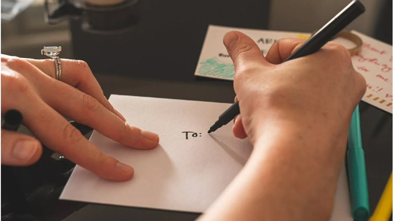 Person writing a letter to a pen pal.