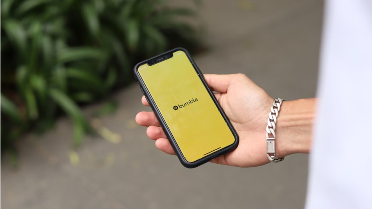 Hand holding phone with Bumble app on it.