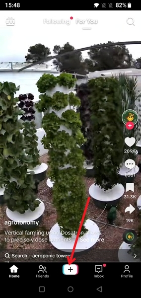 Pressing the "+" button in the TikTok app. 