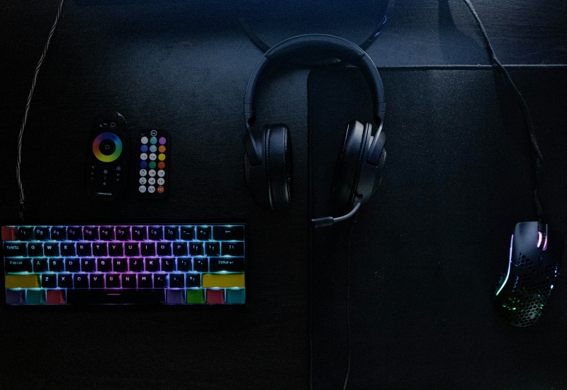 A keyboard. headset, and mouse on a desk