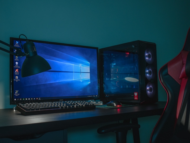 Gaming PC setup on a desk with a lamp and a chair