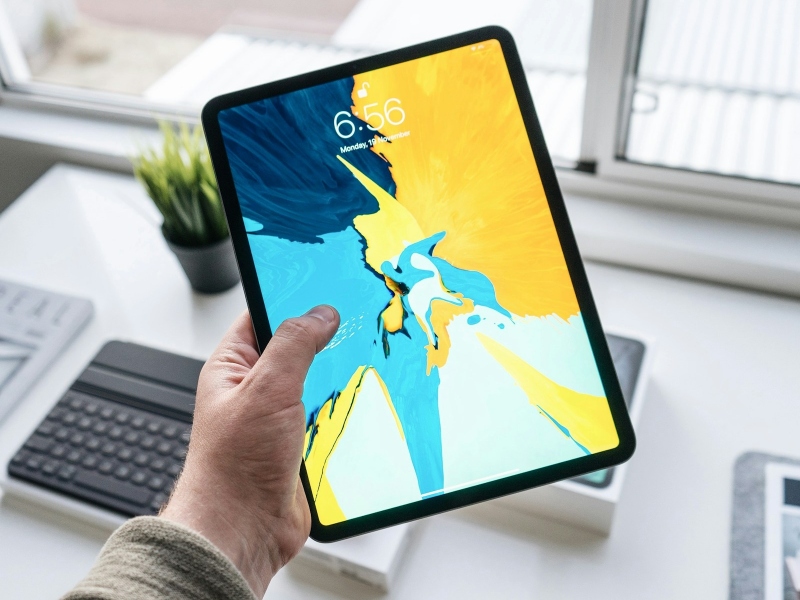 Person holding a black iPad in their hand