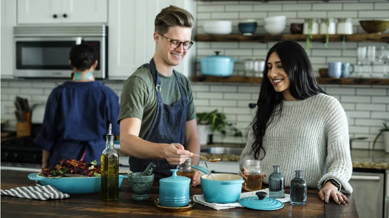 Two people learning to cook in a kitchen.