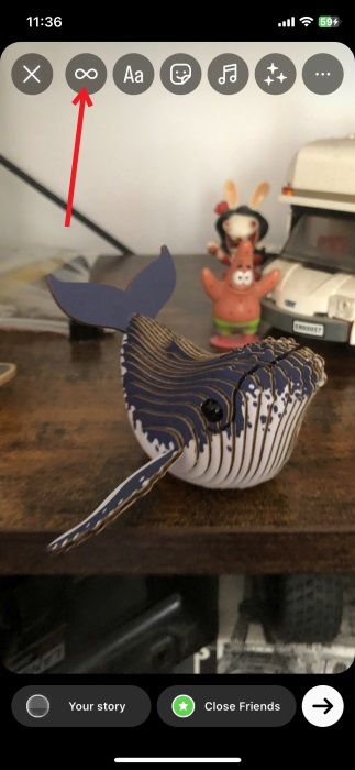 Pressing Boomerang icon in Instagram Story creation screen on iPhone.