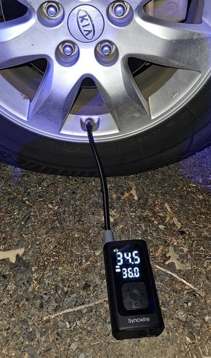 Tire inflator pumping up car tire.