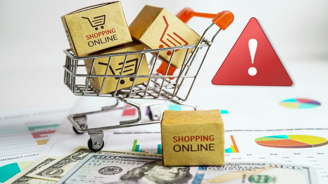 Tiny shopping cart with packages on paper money