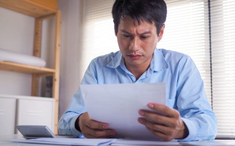 man sad and frustrated looking at paper