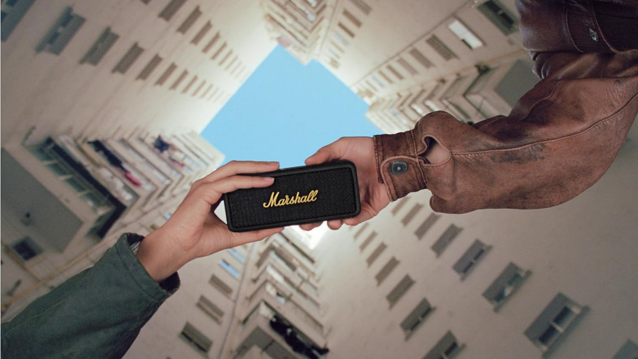 Two People Holding Marshall Speaker