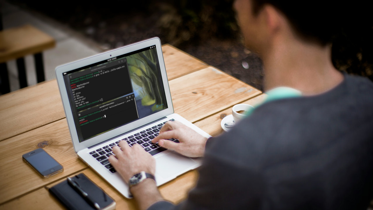 A photograph of a person working on his laptop.