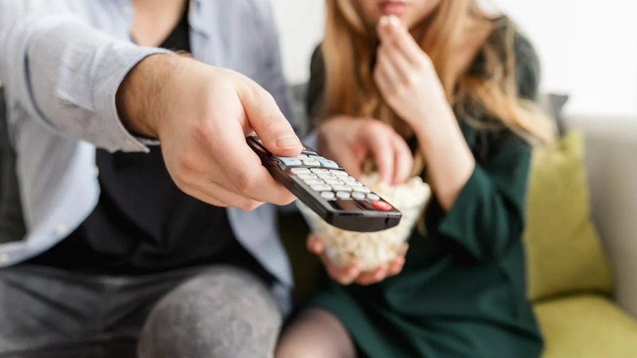 Couple holding a remote.
