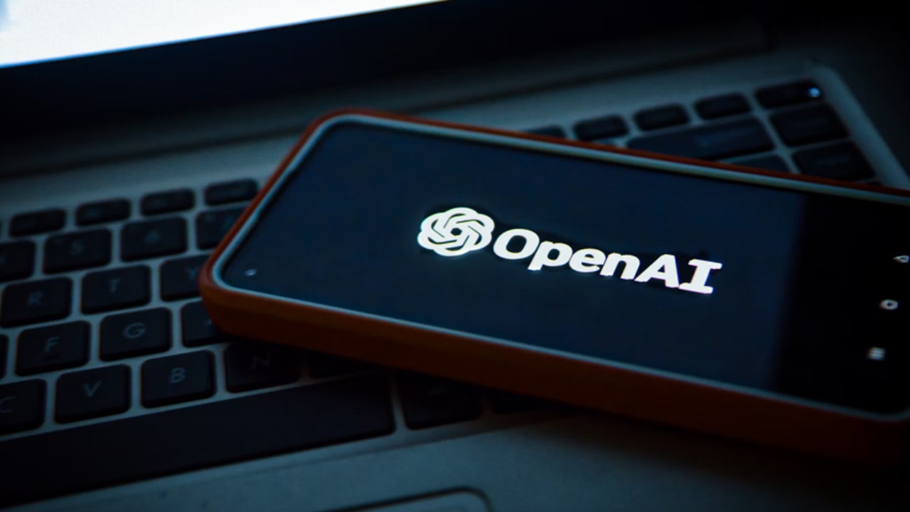 Phone with OpenAI laying on a laptop.