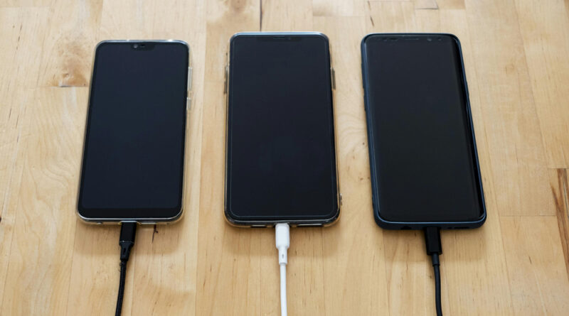 three phones with charging cables connected
