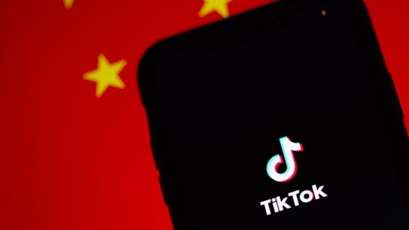 TikTok on phone in front of Chinese flag.