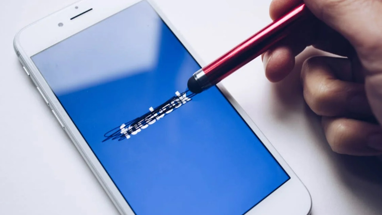 Facebook being scratched out on iPhone.