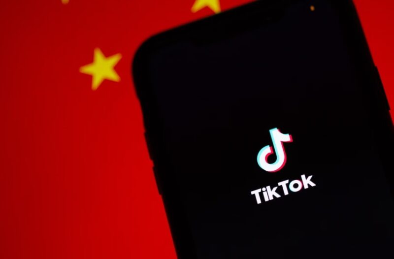 Tiktok on phone against Chinese flag.