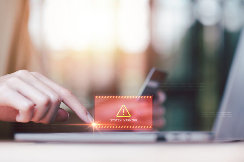 warning pop-up with a laptop in background